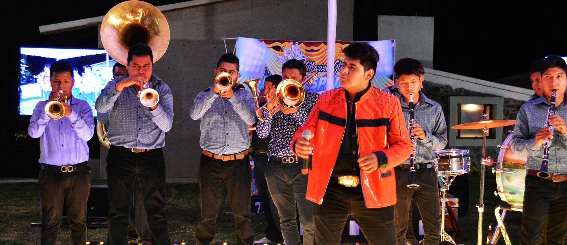 Un grupo de músicos de viento toca entre el público.